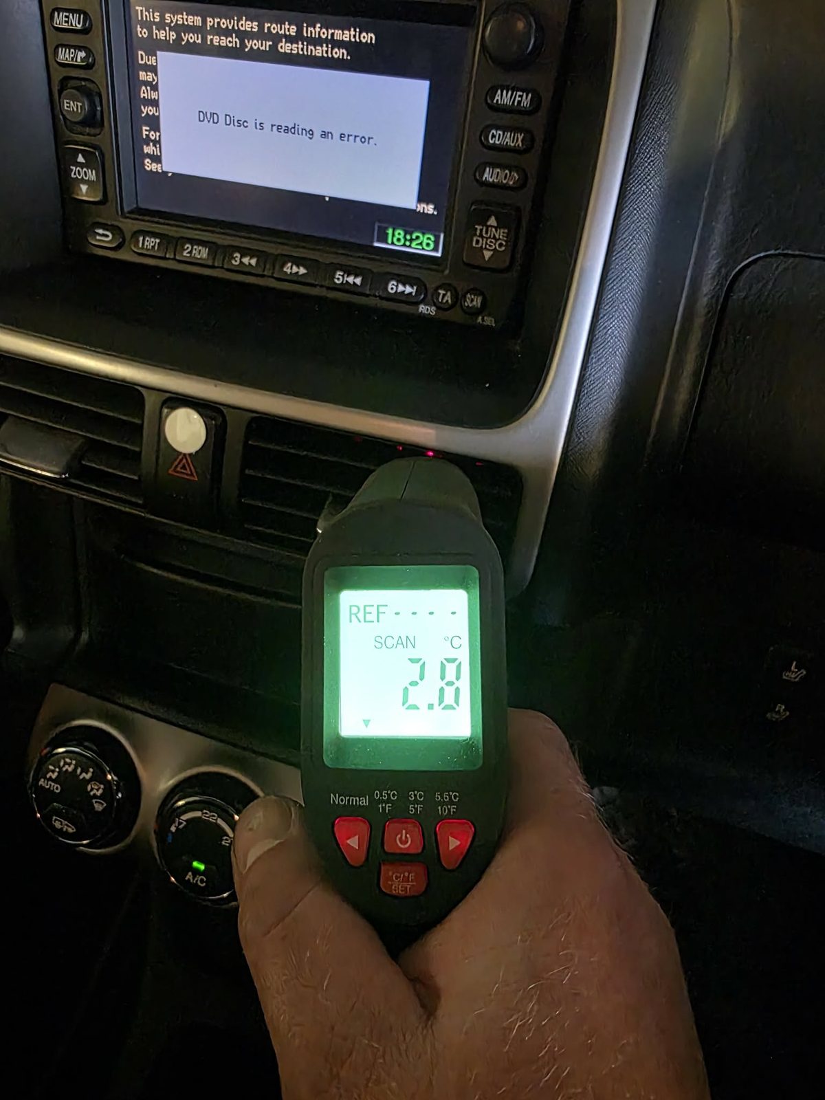 A thermometer reading 2.8 degrees at a dashboard air vent after an AC regas