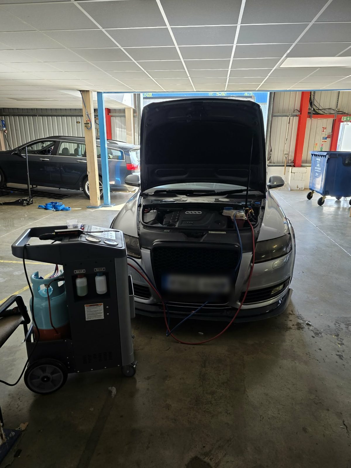 Air con regas machine connected to an Audi with its bonnet up